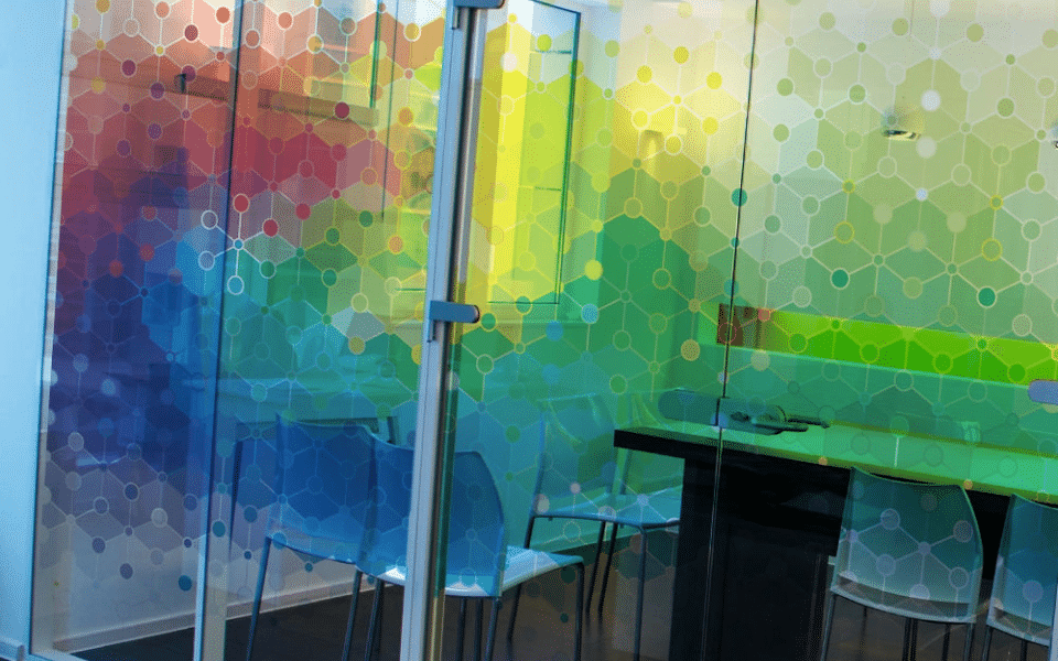 A glass office with a colorful mural on the wall.
